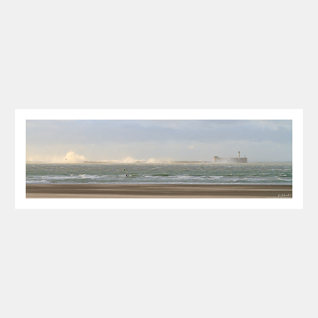Photographie panoramique de la digue Carnot de Boulogne-sur-Mer sous les vagues par gros temps avec un véliplanchiste depuis la plage, Côte d'Opale, Pas-de-Calais, Hauts-de-France, France.
